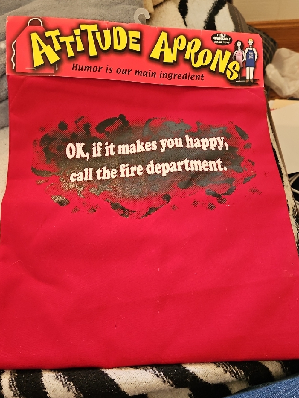 A red ATTITUDE APRONS with the humorous phrase NEW